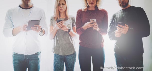 Symbolbild für Barrierefreiheit: 4 Erwachsende surfen auf unterschiedlichen Smartphones und Tablets. (verweist auf: Barrierefreiheit – EU-Richtlinie 2016/2102)